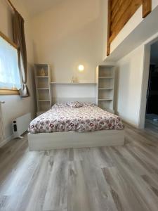 a bedroom with a bed and wooden floors at CASA LOLA in Falcade +6 photos