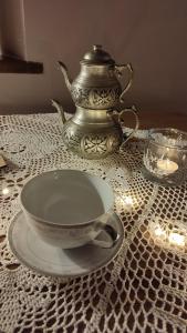 dzbanek do herbaty i miskę na stole z lampkami w obiekcie Chopina 6 na zielonym wzgórzu w Jedlinie-Zdroju