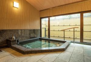 bañera de hidromasaje en una habitación con ventana grande en 高野山 宿坊 普門院 -Koyasan Shukubo Fumonin- en Koyasan