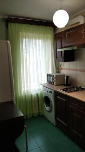 クラスノダールにあるApartment on Dmitriya Blagoyevaのキッチン(洗濯機付)、窓が備わります。