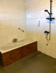 a bath tub in a bathroom with a shower at Tropical Breeze Apartments in Paramaribo