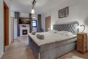 a bedroom with a large bed and a fireplace at Sobe "Ela" in Fužine