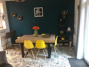 une salle à manger avec une table et des chaises jaunes dans l'établissement Dinard-jolie maison au calme proche plage, à Dinard
