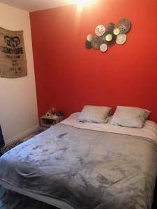 ein Schlafzimmer mit einem Bett mit einer roten Wand in der Unterkunft Dinard-jolie maison au calme proche plage in Dinard