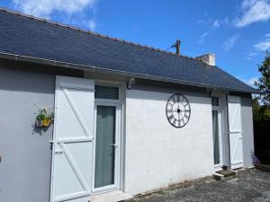 un garage blanc avec une porte et une roue dessus dans l'établissement Dinard-jolie maison au calme proche plage, à Dinard