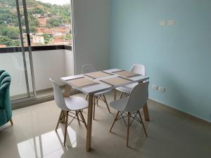 einen Tisch und Stühle in einem Zimmer mit Fenster in der Unterkunft Bello Apartamento , Ubicado en el mejor sector in Cúcuta