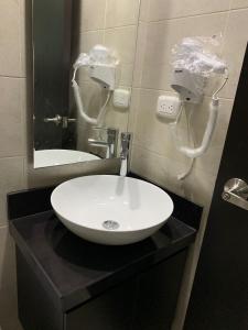 ein Badezimmer mit einem weißen Waschbecken und einem Spiegel in der Unterkunft Bello Apartamento , Ubicado en el mejor sector in Cúcuta