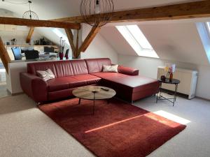 a living room with a red couch and a table at Landhausidyll Apartment Wohn- und Schlafzimmer in Klütz