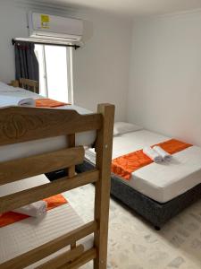 a bedroom with two bunk beds and a window at Cabaña Gaia Rodadero in Santa Marta