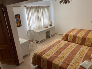 Los Corozos Apartment G1 Guavaberry Golf & Country Club في خوان دوليو: غرفة نوم بسريرين ومكتب ونافذة