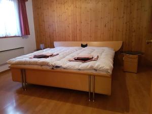 a bed in a room with a wooden wall at Imseng in Wiler