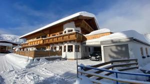 una casa en la nieve con una valla en TiroLiving, en Berwang