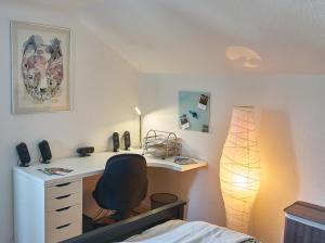 a bedroom with a desk with a chair and a lamp at Green-Art-Living im Allgäu für 4 mit Queensize & WIFI in Lauben