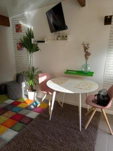 a living room with a table and two chairs at Bungalow la Bohémienne in Oissel