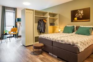 una camera da letto con un grande letto con cuscini verdi di B&B La Vita Verde a Susteren