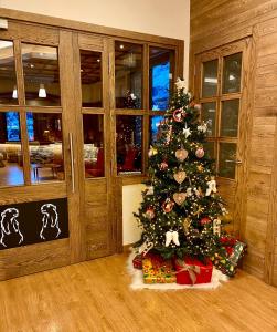 un arbre de Noël avec des cadeaux dans une pièce dans l'établissement Hotel Lacreu, à Salardú