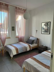 a bedroom with two beds and two windows at Sonnige Wohnung im Herzen von Bühl in Bühl