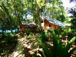 uma pequena casa no meio de uma floresta em Santi Garden Bungalows em Iboih