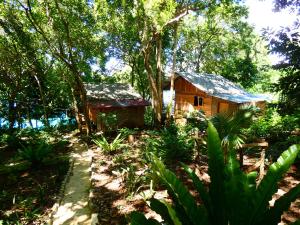 una pequeña casa en medio de un bosque en Santi Garden Bungalows en Iboih