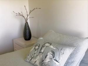 a bedroom with a pillow and a vase on a bed at Maungatautari Outlook Cambridge in Cambridge