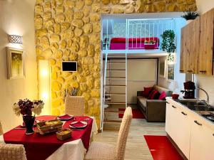 kuchnia ze stołem oraz pokój z łóżkiem piętrowym w obiekcie Le Chalet Palermo Centro w mieście Palermo