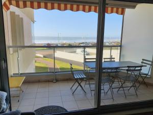 a table and chairs on a balcony with a view of the ocean at RESIDENCE LES BARGES in Saint-Jean-de-Monts