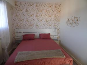 um quarto com uma cama com lençóis vermelhos e almofadas vermelhas em RESIDENCE LES BARGES em Saint-Jean-de-Monts