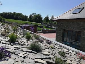 a rock garden with flowers in front of a building at Muckruss Lodge Clonakilty An Oasis of Tranquility in Clonakilty +35 photos