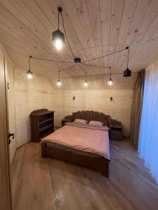 een slaapkamer met een groot bed in een houten kamer bij Майя in Mykulychyn