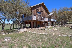 a log house with a wrap around porch at Pond House Bungalow @ Bergheim Ranch in Bergheim