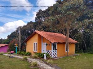 a small yellow house with a red roof at Hospedaje Santaelena -chalets de montaña- in Santa Elena +74 photos