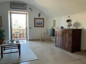 uma sala de estar com uma mesa e uma grande janela em Suite a mare - Casa della Poetessa em Polignano a Mare