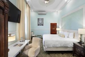 a hotel room with a bed and a desk and chair at Hotel la Perla Leon in León