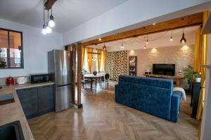 a living room with a blue couch and a kitchen at La Suite de Chantilly - Appartement de 80m2 avec Jacuzzi privé ! in Chantilly