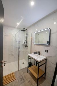 uma casa de banho com um chuveiro, um lavatório e um espelho. em La Suite de Chantilly - Appartement de 80m2 avec Jacuzzi privé ! em Chantilly