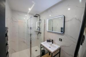 a white bathroom with a sink and a shower at La Suite de Chantilly - Appartement de 80m2 avec Jacuzzi privé ! in Chantilly