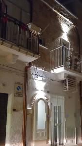 un edificio con puerta blanca y balcón en Romì-Antica dimora, en Polignano a Mare