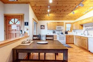 - une cuisine avec une table en bois et un plafond en bois dans l'établissement Trout Creek Condo, à Truckee