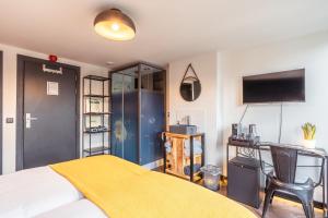 - une chambre avec un lit et une couverture jaune dans l'établissement Hotel De Werf, à Le Helder
