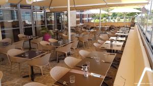 eine Reihe von Tischen und Stühlen in einem Restaurant in der Unterkunft Chic'o Rail in Saint-Omer