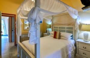 a bedroom with a white bed with a canopy at Casa Chiesa in English Harbour Town +4 photos