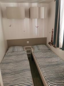 two beds sitting next to each other in a room at Mobile Home Rock 'n' Sea in Sveti Juraj