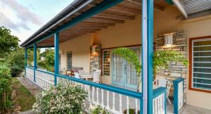 a porch of a house with blue columns at Casa Chiesa in English Harbour Town