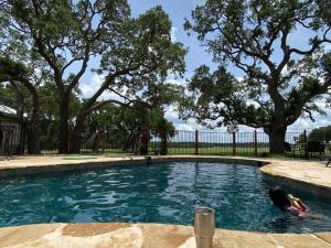 a swimming pool with a person in the water at Pond House Bungalow @ Bergheim Ranch in Bergheim