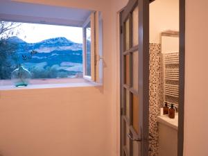 a bathroom with a window with a view of a mountain at MULINU BIANCU in Poggio-dʼOletta