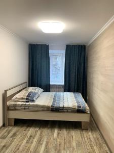 a bedroom with a bed and a window at Зручні апартаменти подобово! Центр. Руська. 3 кімн. in Ternopilʼ +16 photos