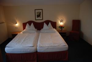 two beds in a hotel room with two lamps at Landhaus Brieger in Henndorf am Wallersee