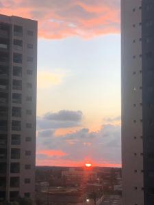 a sunset seen from between two buildings in a city at Apartamento no Salinas Exclusive Resort in Salinópolis