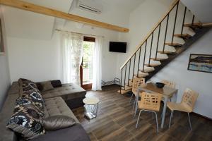 a living room with a couch and a table and stairs at Apartmani ,,Vasa ,, 3 in Soko Banja