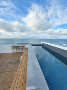 a table on the roof of a building with the ocean at CASA DO SOL in Jardim do Mar